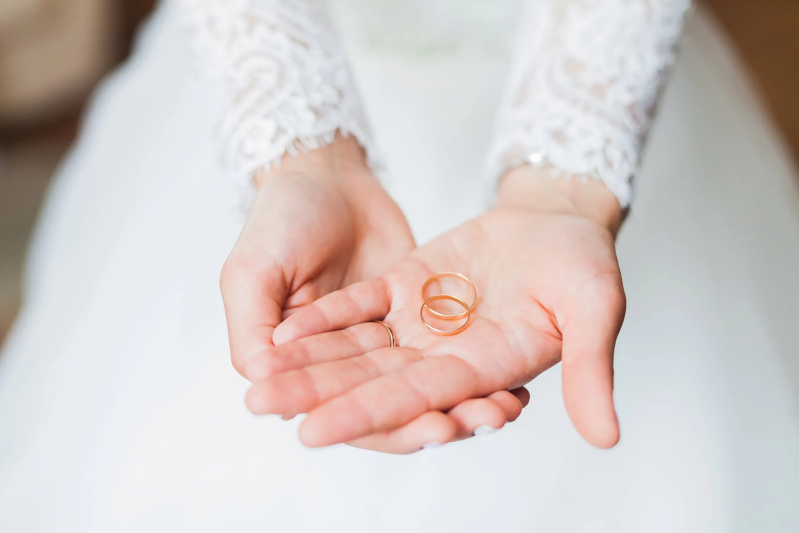The two gold rings that will join them held together by the bride.